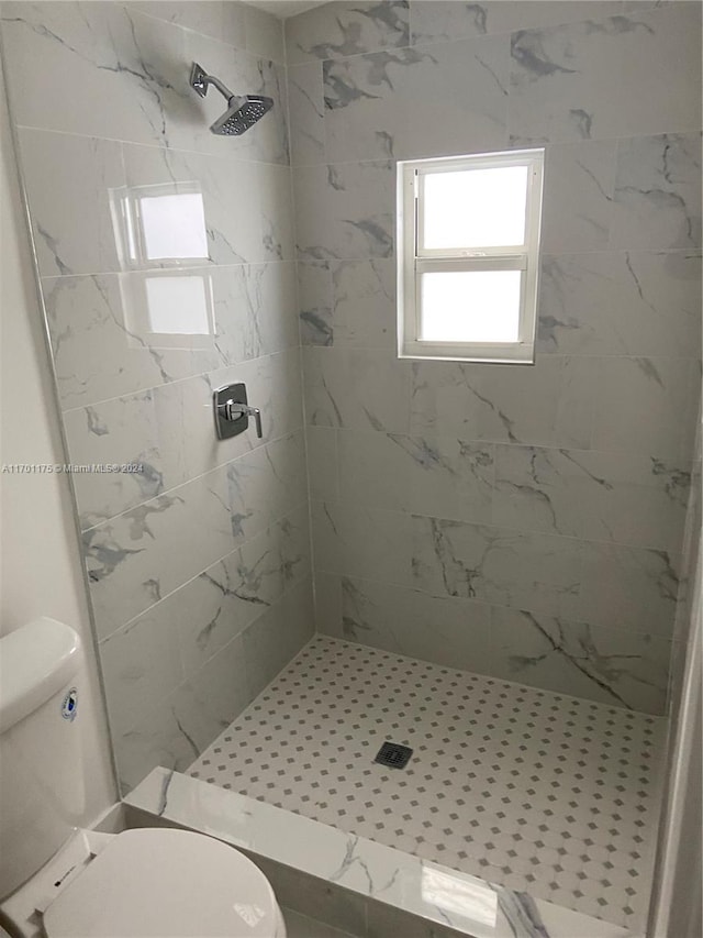 bathroom with toilet and tiled shower