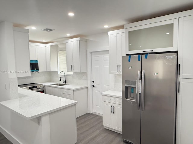 kitchen with sink, white cabinetry, stainless steel appliances, and light wood-type flooring