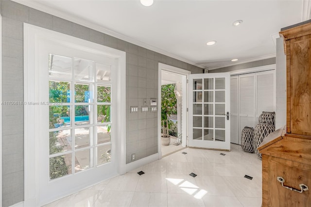 doorway with ornamental molding, tile walls, and a healthy amount of sunlight