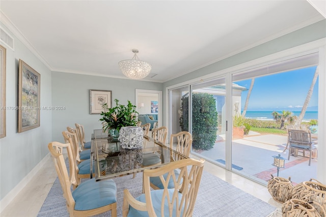 dining room featuring an inviting chandelier, a water view, light tile patterned flooring, and ornamental molding