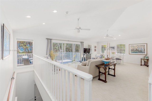 living room featuring ceiling fan, light carpet, and a wealth of natural light