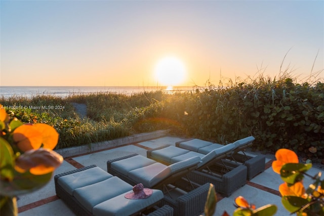 patio terrace at dusk featuring a water view