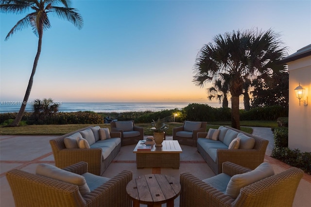 patio terrace at dusk featuring an outdoor hangout area and a water view