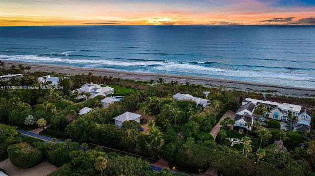 aerial view at dusk featuring a beach view and a water view