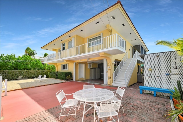 back of property featuring a balcony and a patio area