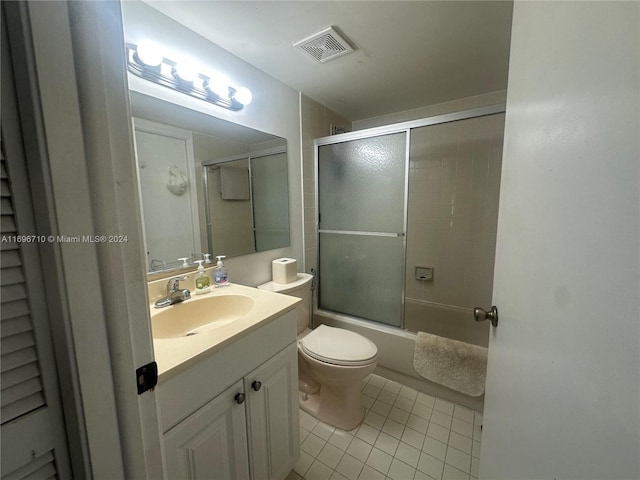 full bathroom with tile patterned flooring, vanity, enclosed tub / shower combo, and toilet