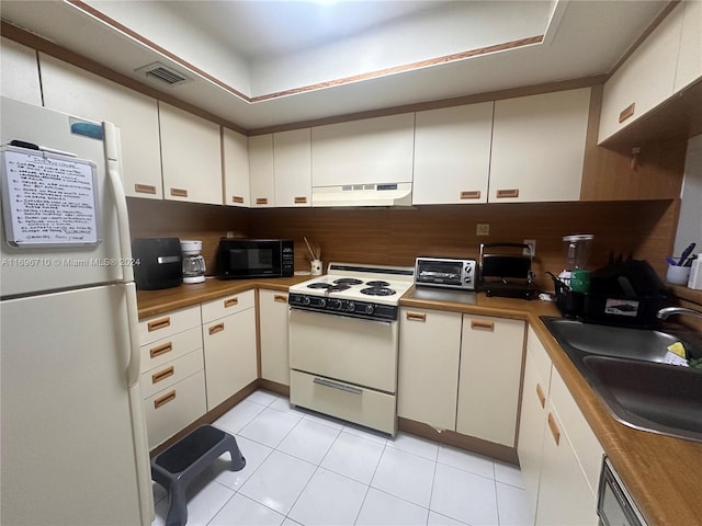 kitchen featuring white appliances, white cabinets, sink, light tile patterned floors, and extractor fan