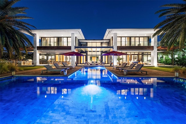 pool at night with a patio area