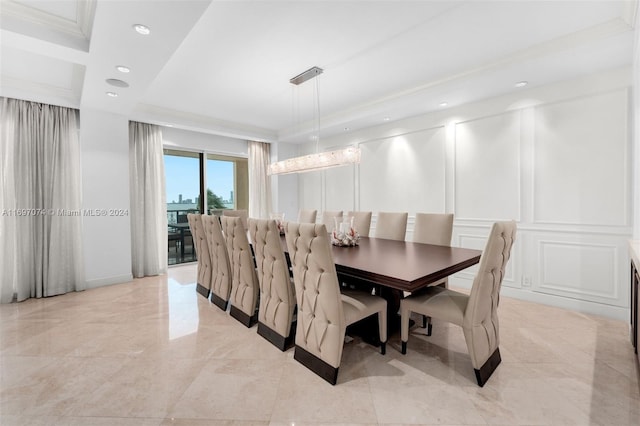 dining space featuring a raised ceiling and ornamental molding