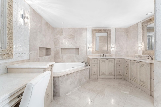 bathroom with vanity, tile walls, and tiled tub