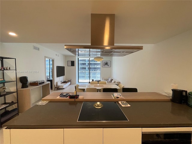 kitchen featuring white cabinetry, island range hood, beverage cooler, and cooktop