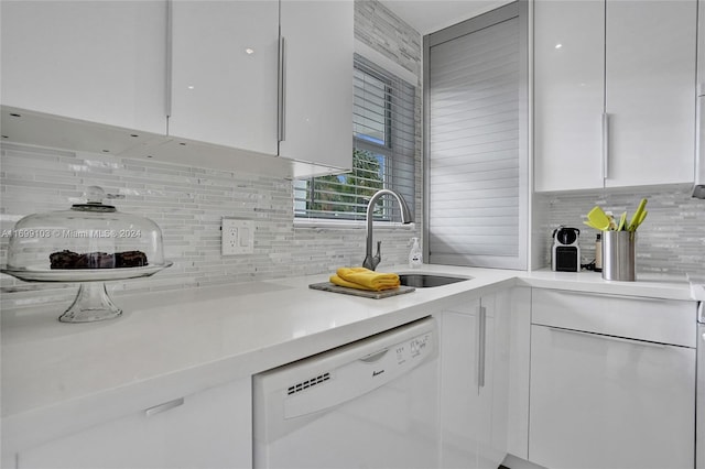 kitchen with white cabinets, decorative backsplash, white dishwasher, and sink