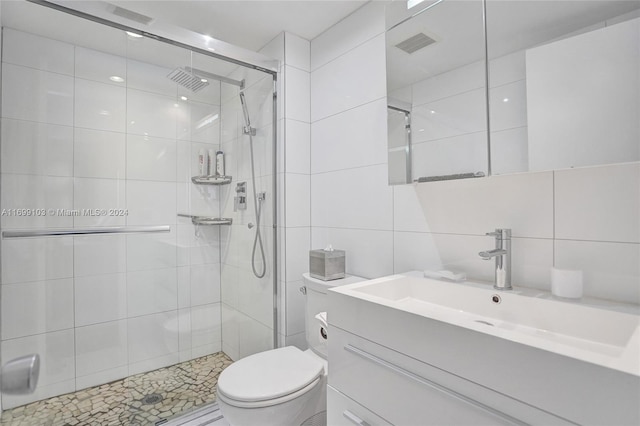 bathroom featuring tasteful backsplash, an enclosed shower, toilet, vanity, and tile walls