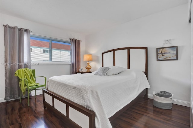 bedroom with dark hardwood / wood-style floors