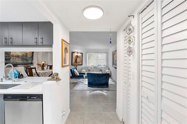 hallway featuring light tile patterned flooring, sink, and a textured ceiling