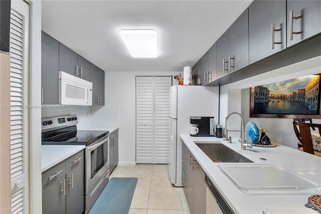 kitchen with light tile patterned flooring, white appliances, sink, and tasteful backsplash