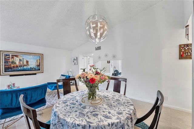 dining area featuring light tile patterned flooring, lofted ceiling, and a textured ceiling