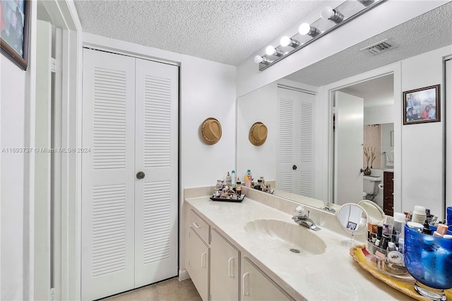 bathroom featuring tile patterned floors, vanity, and a textured ceiling