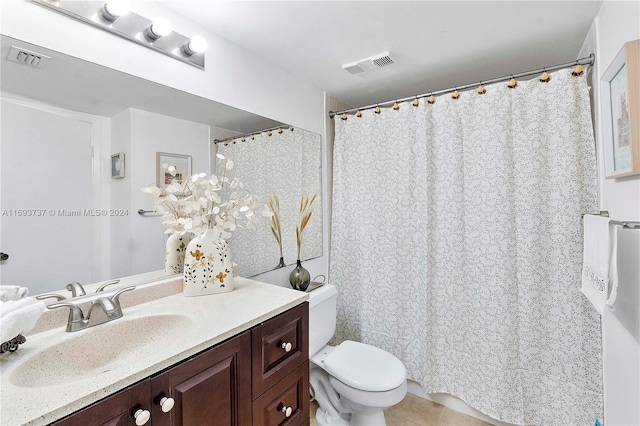 bathroom featuring tile patterned flooring, vanity, and toilet