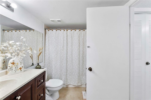 bathroom featuring tile patterned flooring, vanity, and toilet