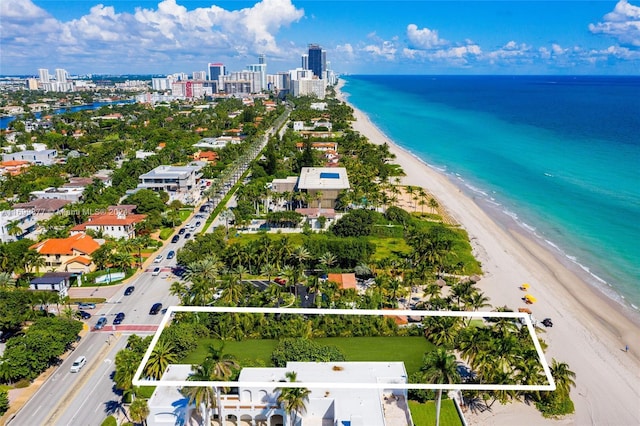 drone / aerial view with a water view and a beach view