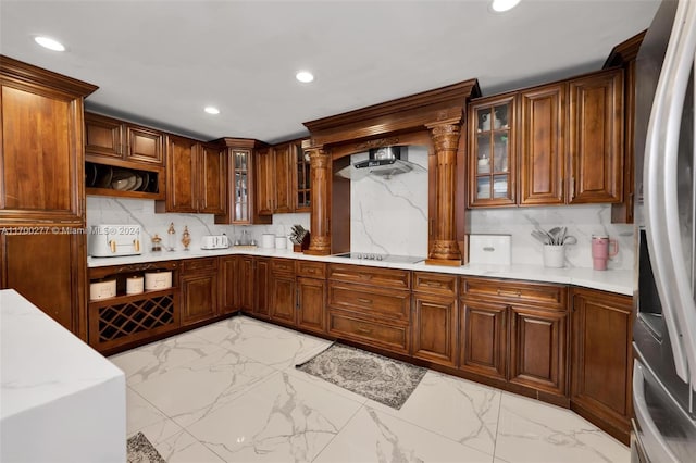 kitchen featuring backsplash, wall chimney range hood, black electric cooktop, stainless steel fridge with ice dispenser, and decorative columns