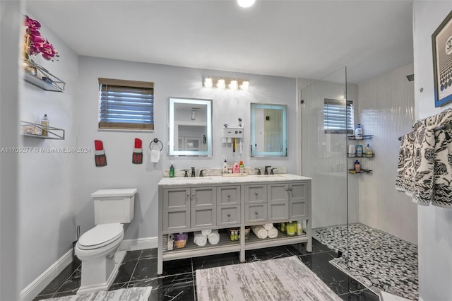 bathroom featuring vanity, toilet, and a tile shower