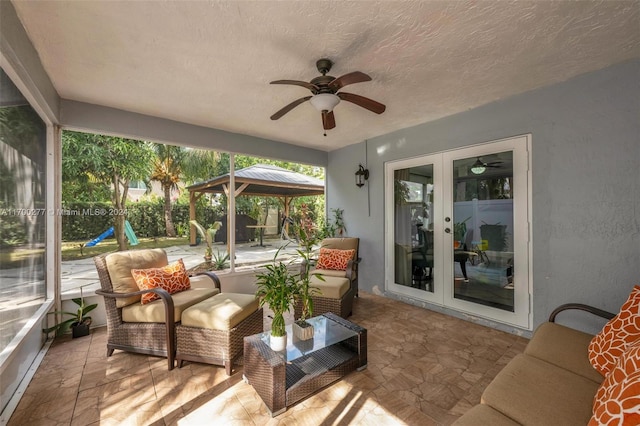 sunroom featuring ceiling fan and french doors