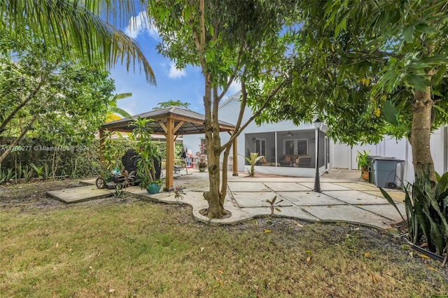 view of yard featuring a sunroom, a gazebo, and a patio