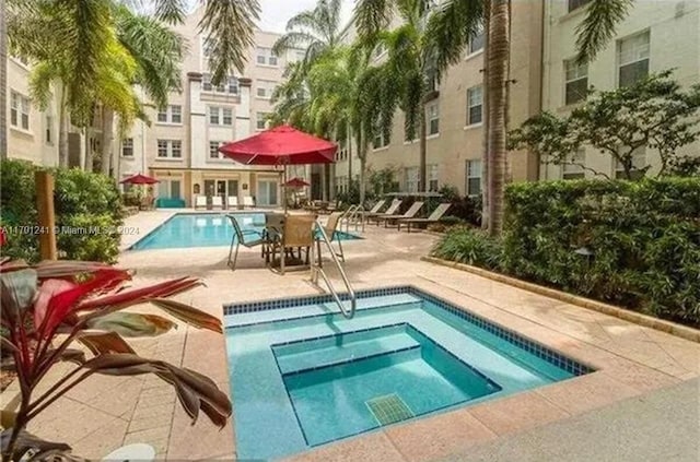 view of pool with a patio and a hot tub