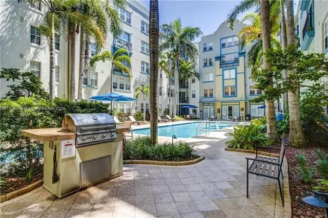 view of swimming pool with grilling area and a patio