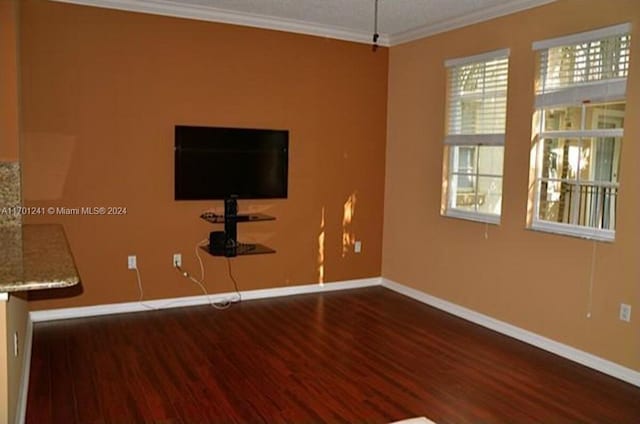 empty room with dark hardwood / wood-style floors and ornamental molding