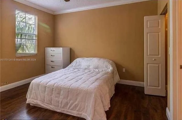 bedroom featuring ceiling fan, dark hardwood / wood-style flooring, and ornamental molding