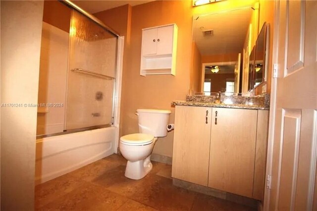 full bathroom with vanity, enclosed tub / shower combo, and toilet