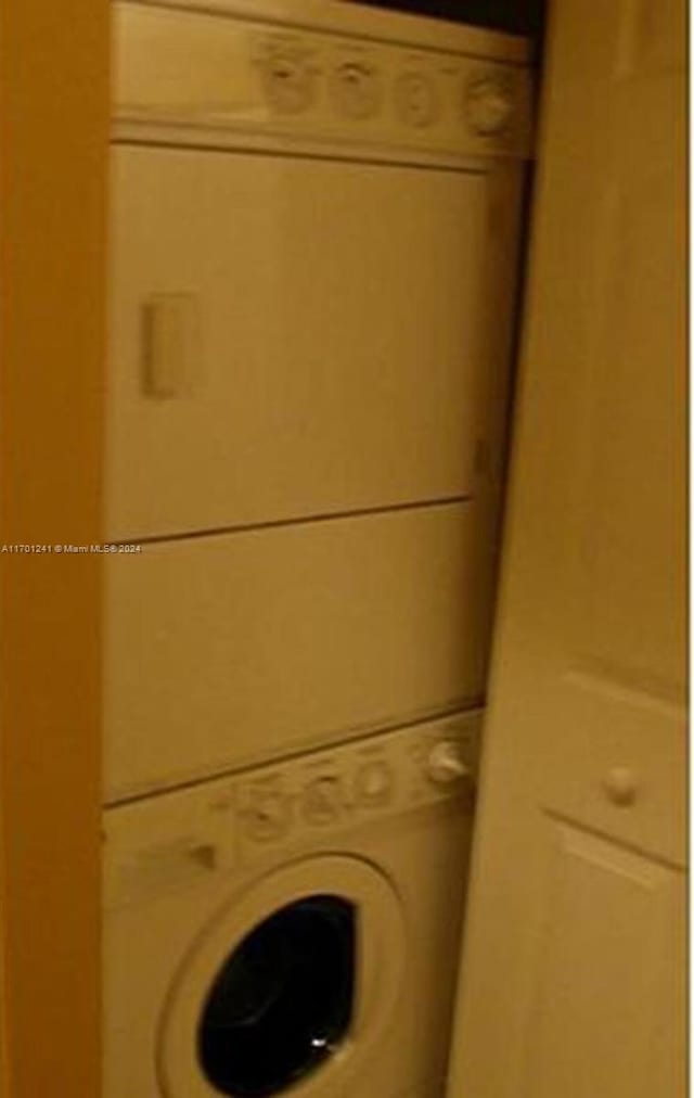 clothes washing area featuring stacked washer and dryer