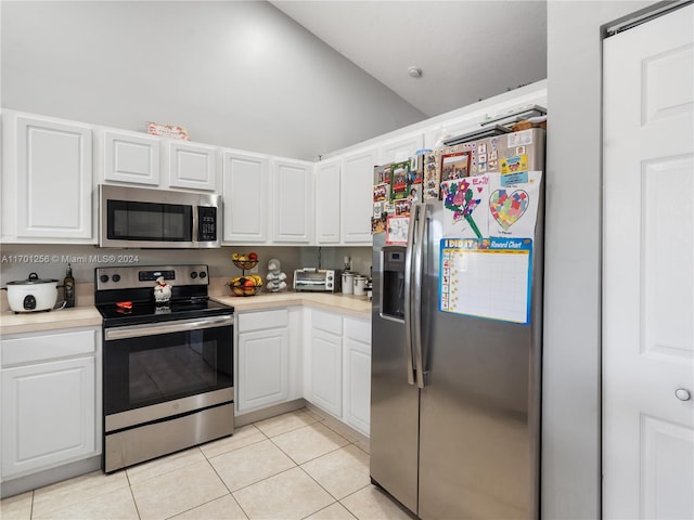 kitchen with white cabinetry, light tile patterned flooring, stainless steel appliances, and lofted ceiling