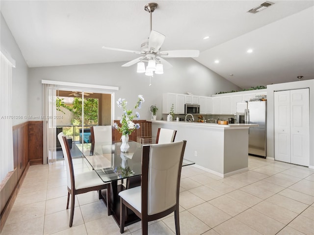 tiled dining room with ceiling fan and lofted ceiling