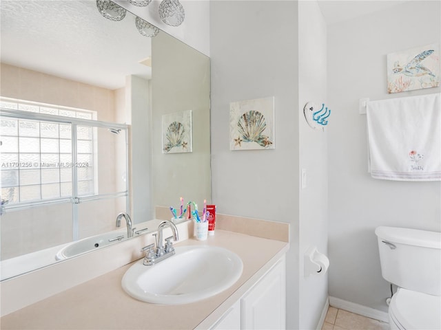 bathroom with tile patterned flooring, a textured ceiling, vanity, and toilet