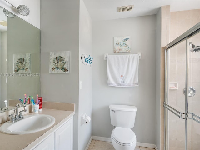 bathroom with tile patterned floors, vanity, toilet, and a shower with shower door