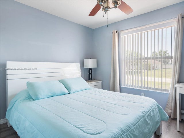 bedroom with wood-type flooring, multiple windows, and ceiling fan