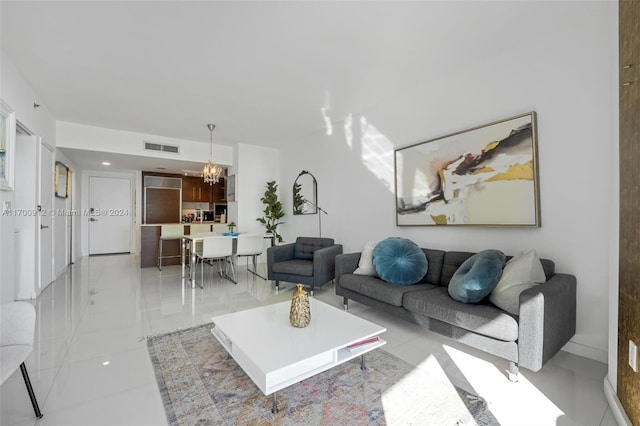 living room with light tile patterned flooring and an inviting chandelier