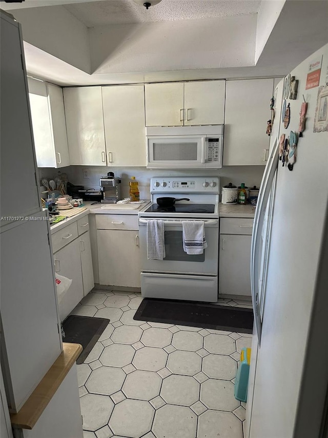 kitchen featuring a textured ceiling and white appliances