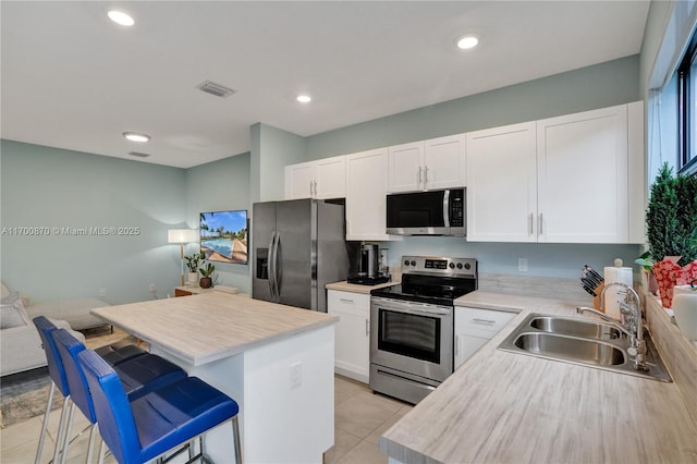 887 NE 211th St Unit 887, Miami, FL 33179 - kitchen with a sink, stainless steel appliances, light countertops, and white cabinetry