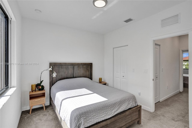 bedroom featuring light carpet and a closet