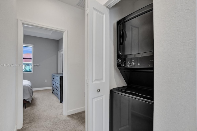 887 NE 211th St Unit 887, Miami, FL 33179 - laundry area featuring visible vents, stacked washer / dryer, light carpet, laundry area, and baseboards