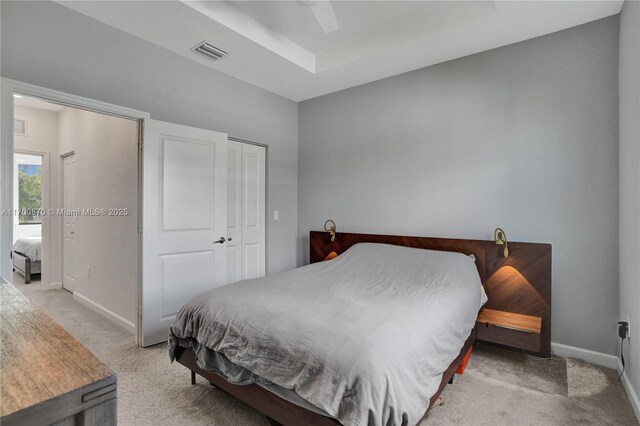 laundry room with stacked washer and dryer and light colored carpet