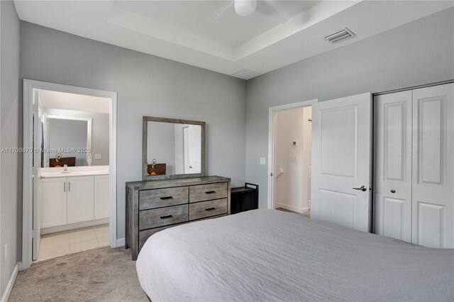 bedroom with a tray ceiling, ceiling fan, and light colored carpet