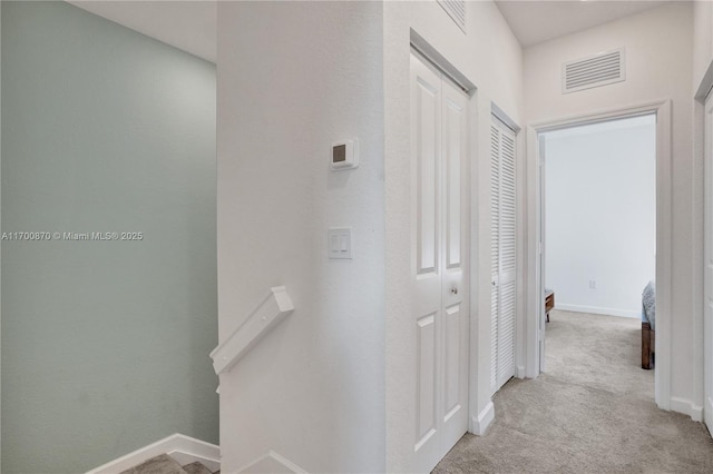 887 NE 211th St Unit 887, Miami, FL 33179 - corridor with light colored carpet, baseboards, visible vents, and an upstairs landing