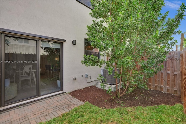 887 NE 211th St Unit 887, Miami, FL 33179 - view of exterior entry featuring fence, central AC, and stucco siding