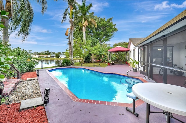 view of pool featuring a gazebo, a sunroom, a water view, and a patio